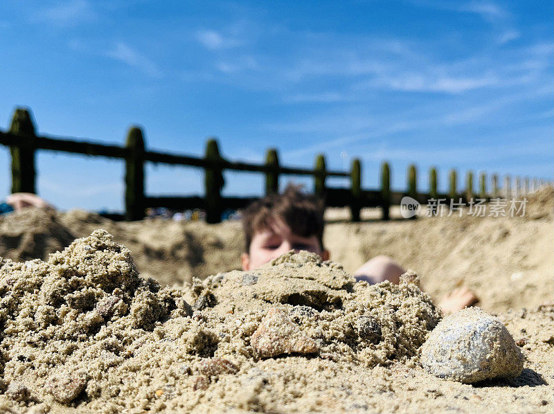 男孩在沙滩上挖土