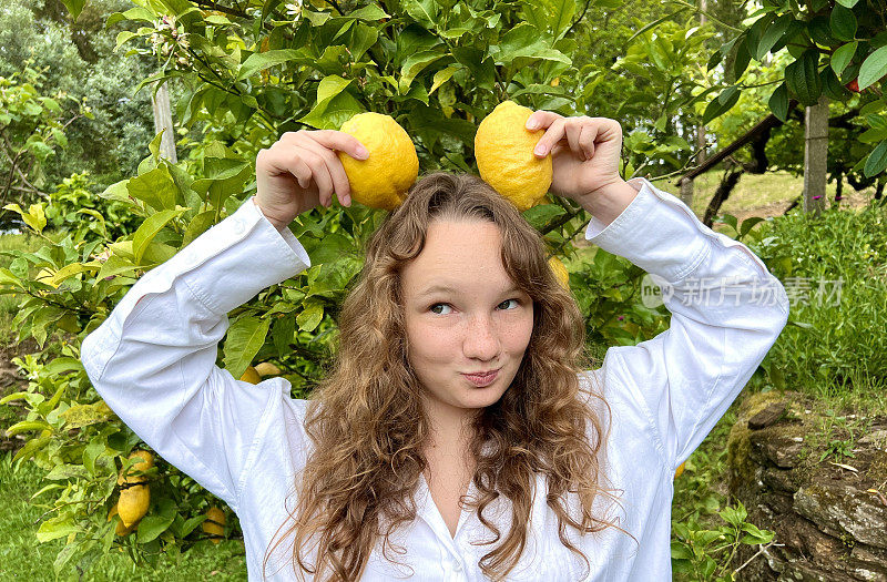 热带国家柠檬生长在树上金发女孩与柠檬玩在框里瞎胡闹