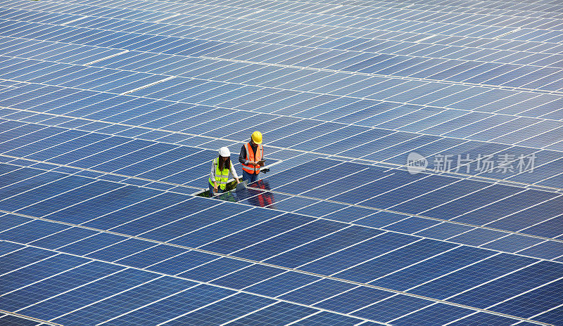 太阳能电池工程师在太阳能屋顶工地一线工作，可持续能源，可再生和绿色能源的概念