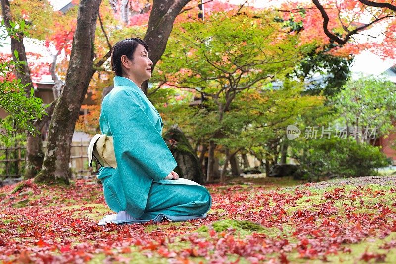 日本女子在传统的日本旅社花园冥想