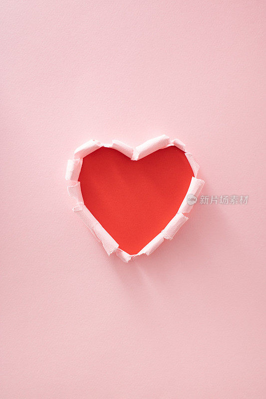 红色的心是用粉红色的纸做的。最小限度的爱或情人的概念。