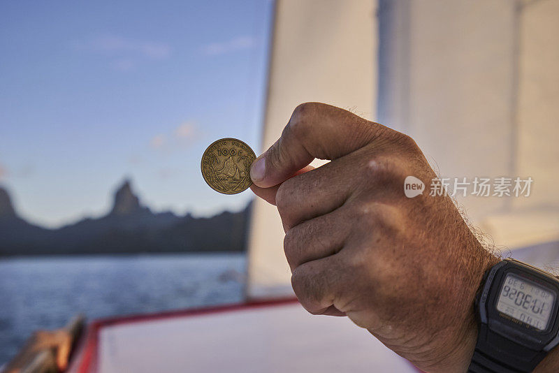 手与数字手表持有旧硬币在船上