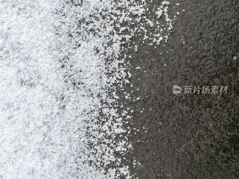 雪部分盖在柏油路上