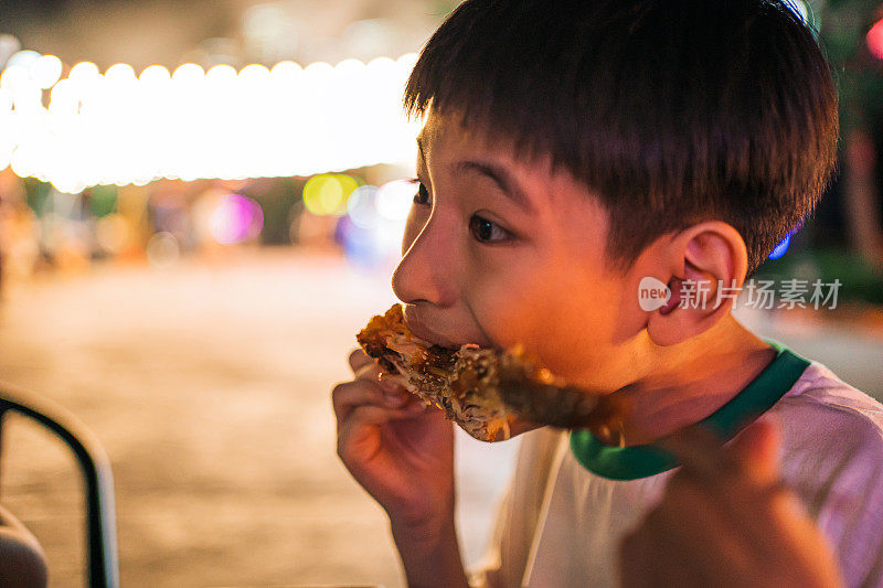 一个男孩在吃鸡翅