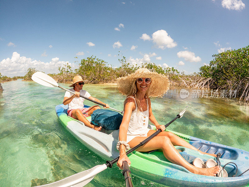 一对情侣在热带泻湖划独木舟享受国外度假，自拍