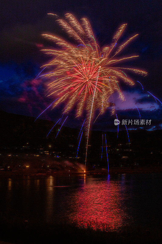 科罗拉多斯普林斯湖的烟花，以派克峰山脉为背景，美国西部的郊区灯光