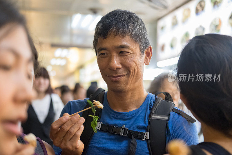 台湾台北，多代华人家庭在美食广场品尝小吃