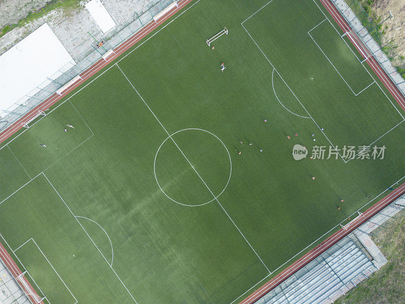 足球运动员在草地上进行比赛的鸟瞰图。空中室外体育场人造草