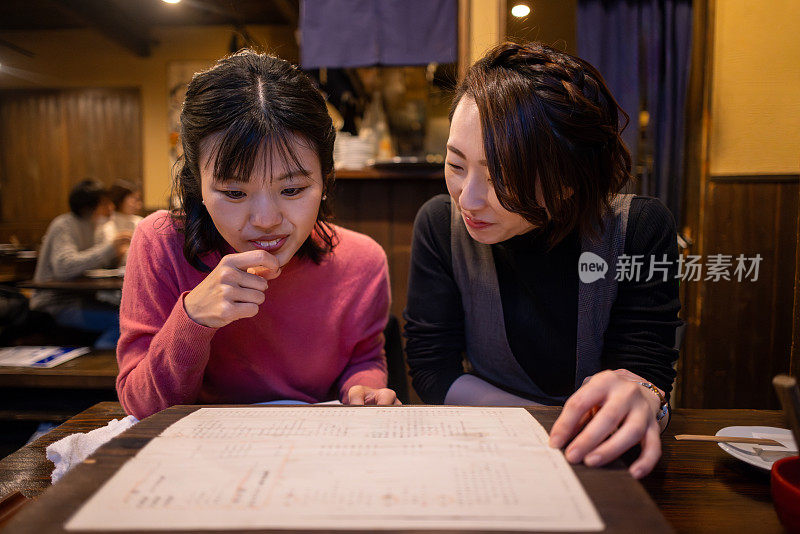 女性朋友在日本餐厅看菜单吃饭