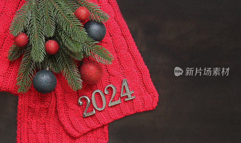 2024年新年快乐。人工杉树枝上织一条红领巾，暗木背景