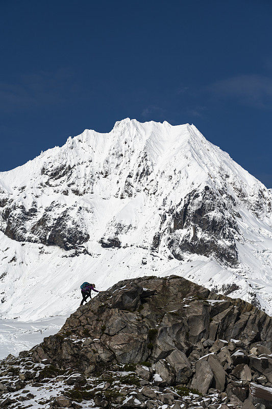 徒步旅行者在雪山下的山脊上休息