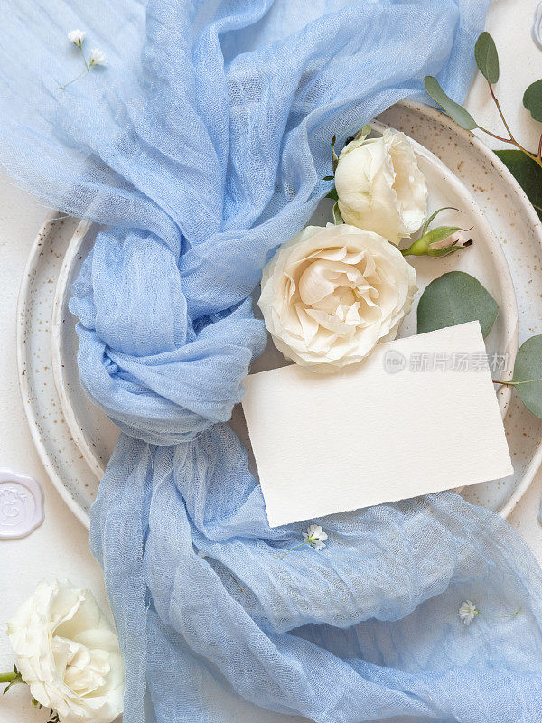 卡片附近浅蓝色薄纱织物结和奶油玫瑰在盘子上顶部查看复制空间，婚礼模型