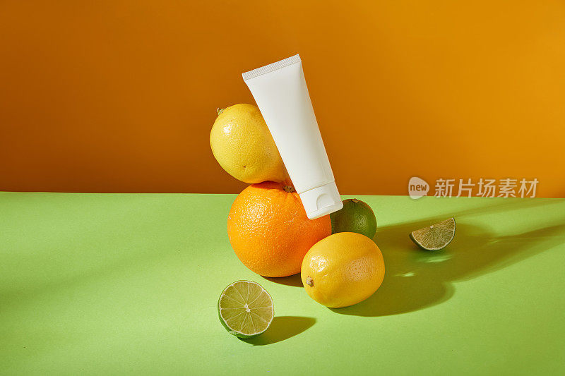 一些柑橘类水果堆在一个没有标签的管靠在前面的视图，橙色背景。用于添加文本和设计元素的空白空间