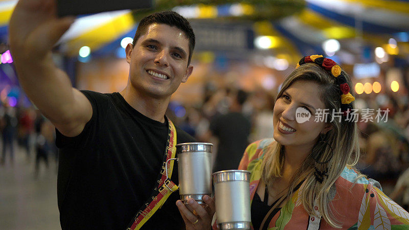 在巴西圣卡塔琳娜的布鲁梅瑙啤酒节上，一对年轻夫妇在自拍