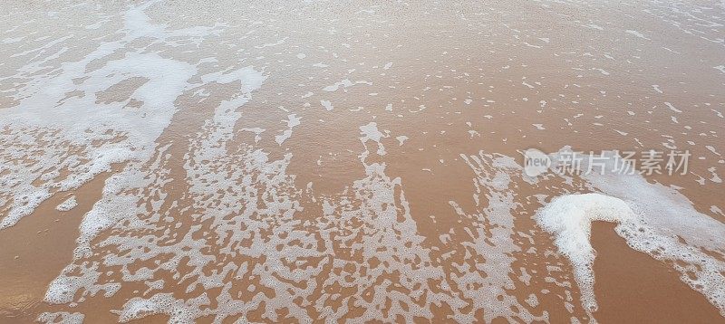 泡沫状的白色海浪拍打着海滩