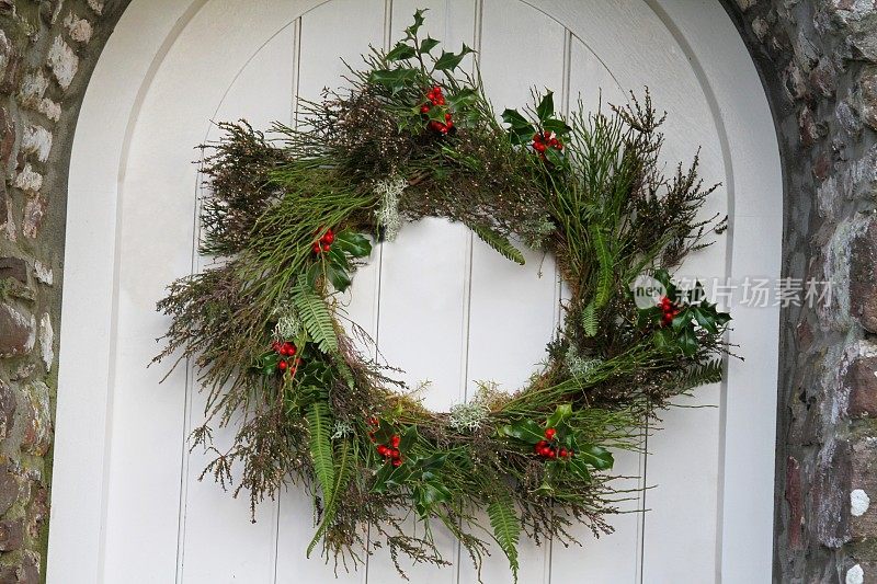 圣诞冬青花环挂在木门上