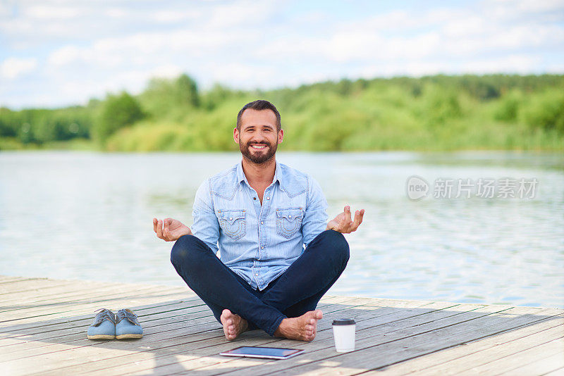 穿着休闲服装的现代商人用数码平板电脑冥想