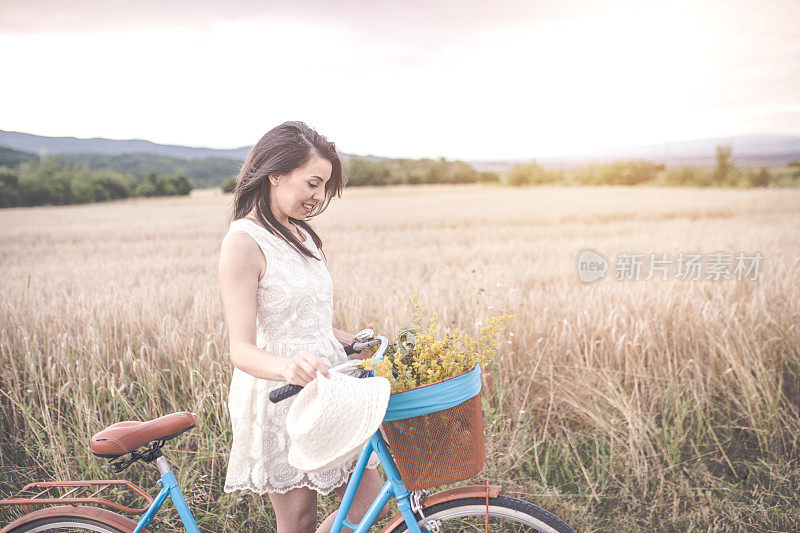 骑着自行车的女人在麦田里。