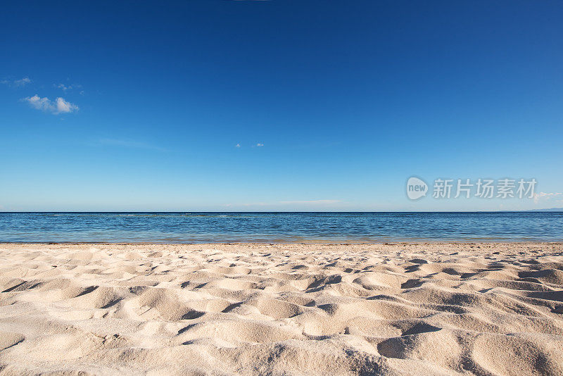 空旷的沙滩和蓝天背景下的大海