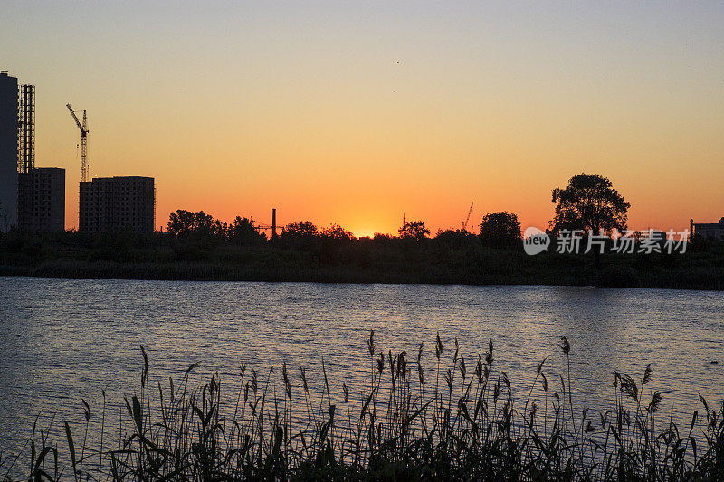 城市的日落或日出。现代住宅区附近的圣彼得堡，俄罗斯库普契诺池塘。