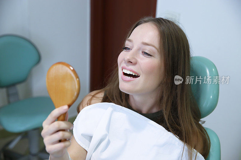 一名年轻的女牙医在成功选择了假牙后很开心