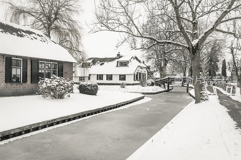 在一个寒冷但美丽而平静的冬天，Giethoorn村的运河和积雪