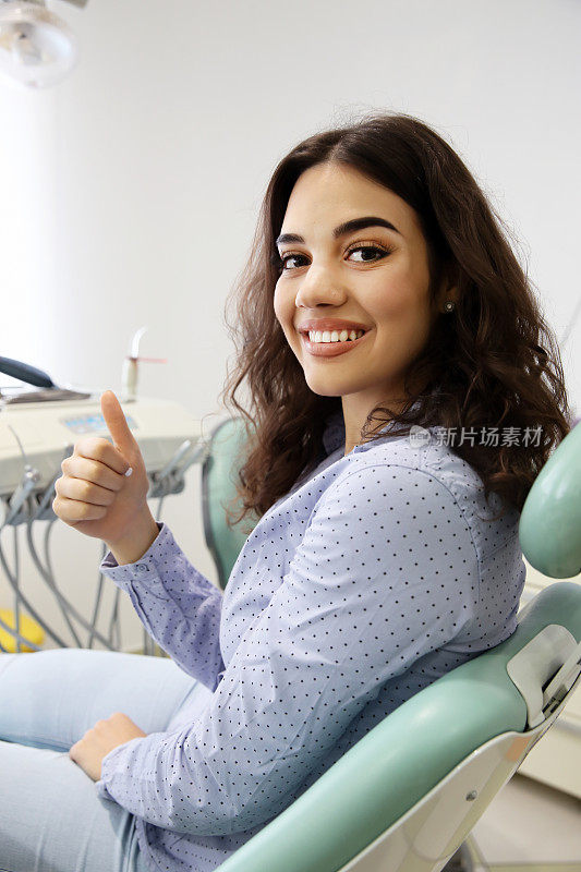 年轻美丽的女人后成功的牙科治疗
