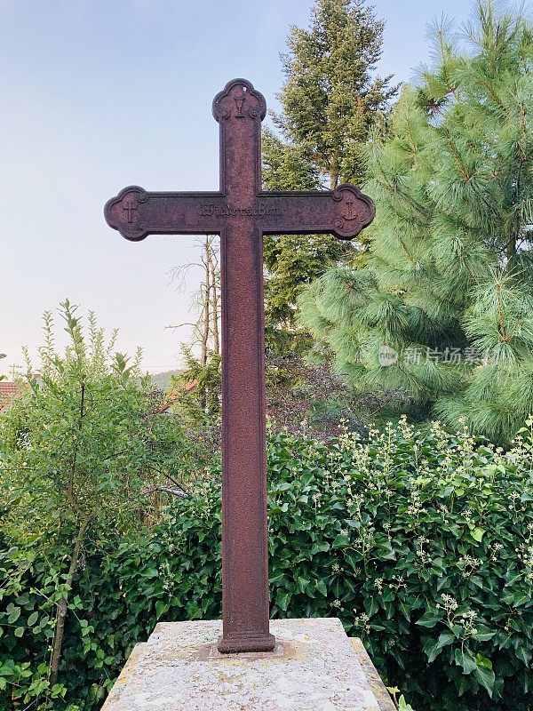 老风化生锈的十字架在墓碑上