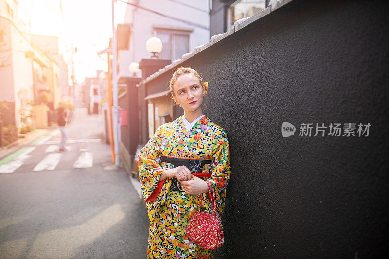 穿着和服的年轻白人妇女走在传统的日本街道上