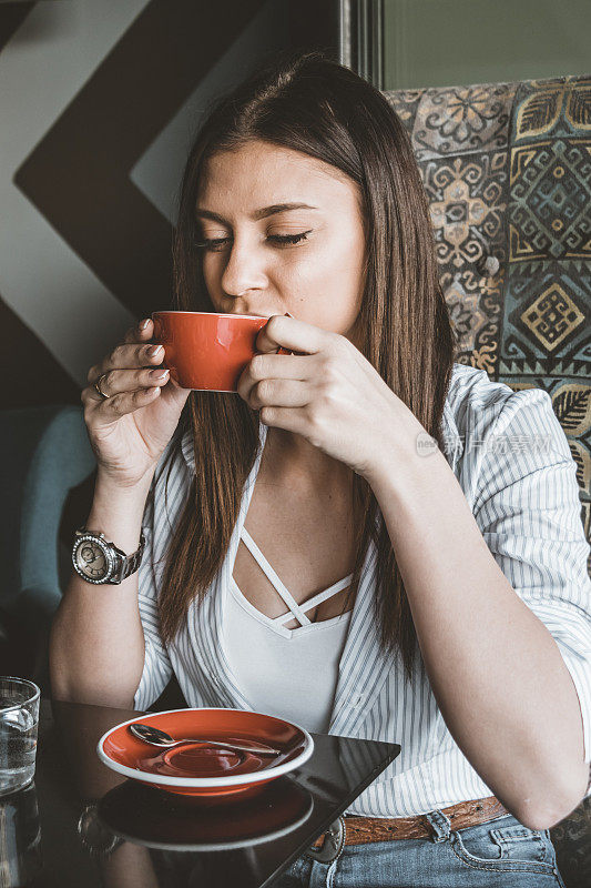 一个女人正在享用一杯咖啡，网址是Café