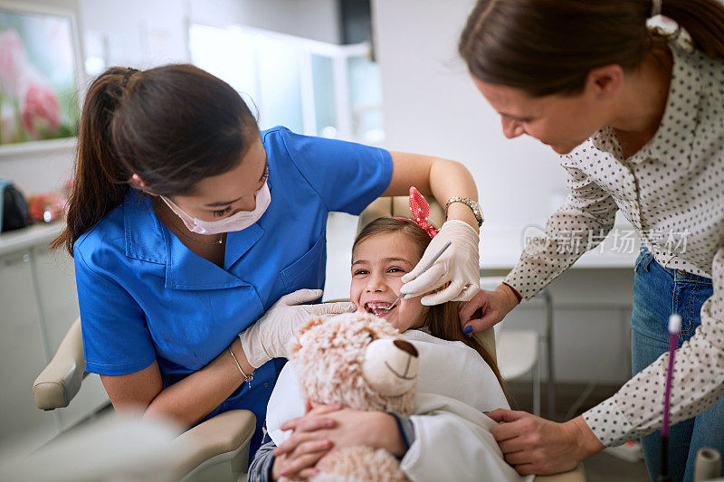 小女孩看牙医。牙医在门诊检查牙齿病人。