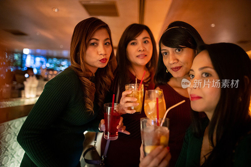 亚洲女性朋友在酒吧合影