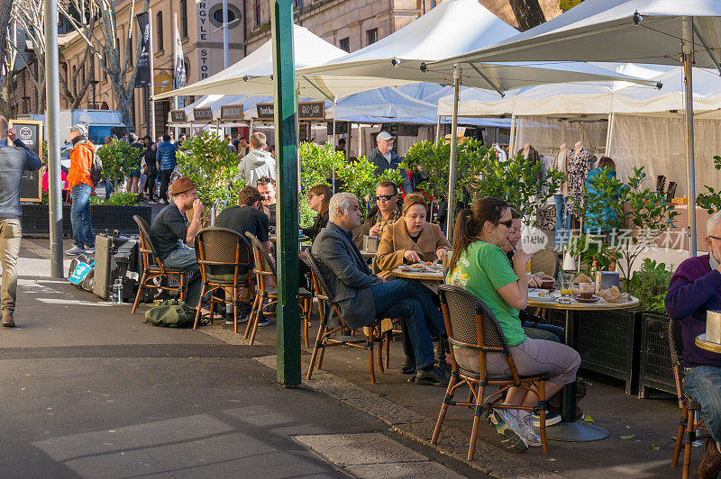 人们在悉尼的岩石区的户外餐厅用餐