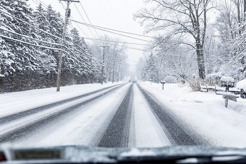 冬季暴风雪期间在湿滑的乡村公路上的汽车观点