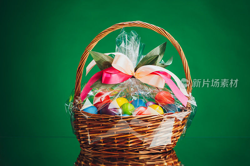 复活节礼品篮有多种颜色的鸡蛋，绿色的背景