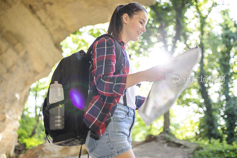 一个女人一边看地图一边走在山上