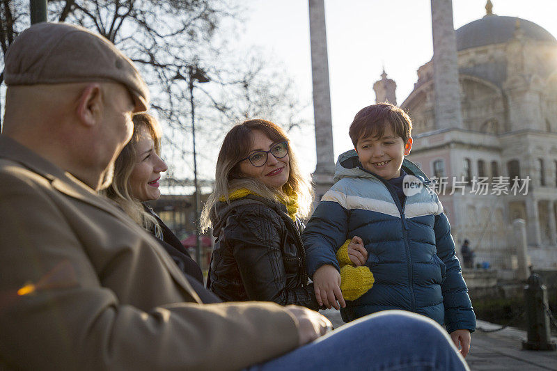 一家人坐在Ortakoy清真寺外。