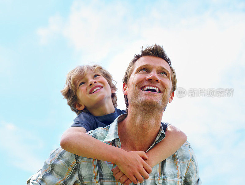 快乐成熟的男人给儿子骑背对天空