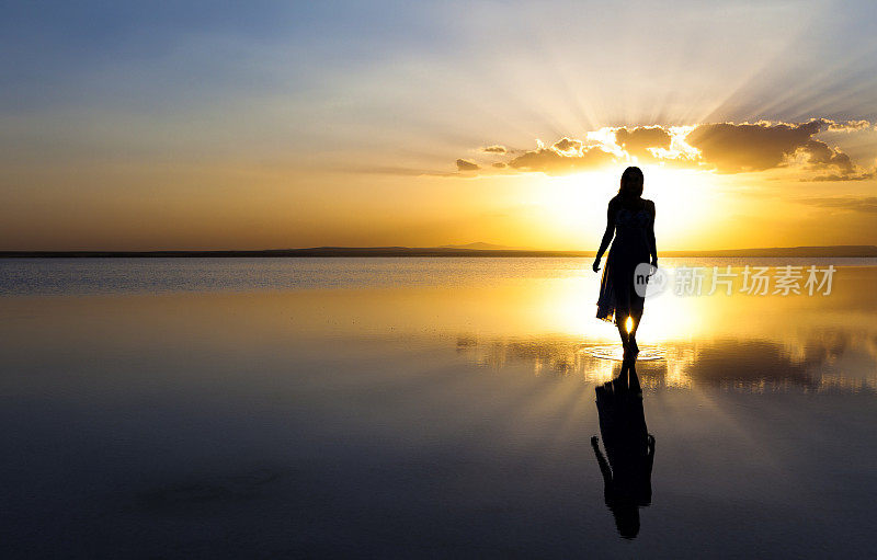 日落时分，年轻女子在水上行走