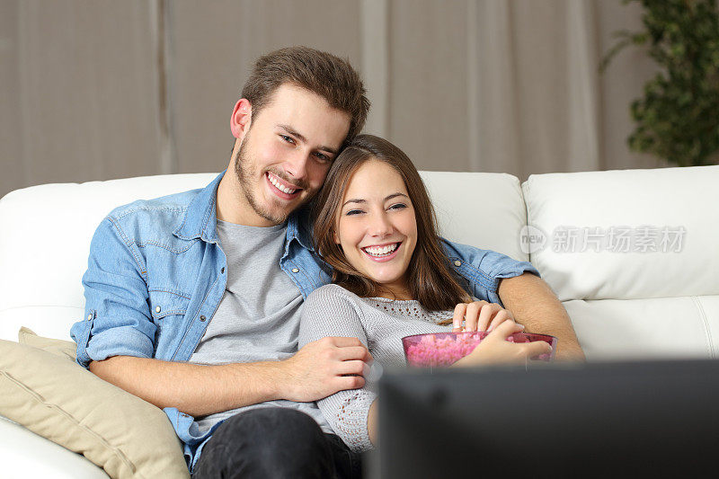 一对幸福的夫妇在电视上看电影