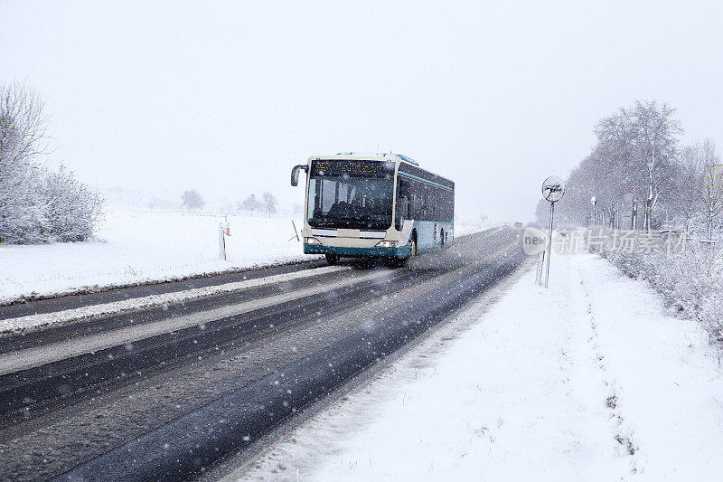 公交车在冬天的路上，下着大雪