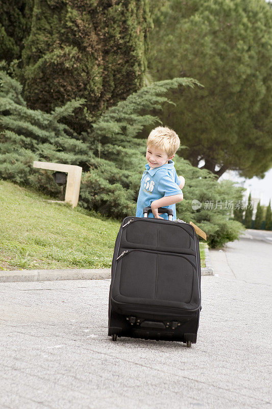 在机场拿着行李箱的独立年轻旅行者