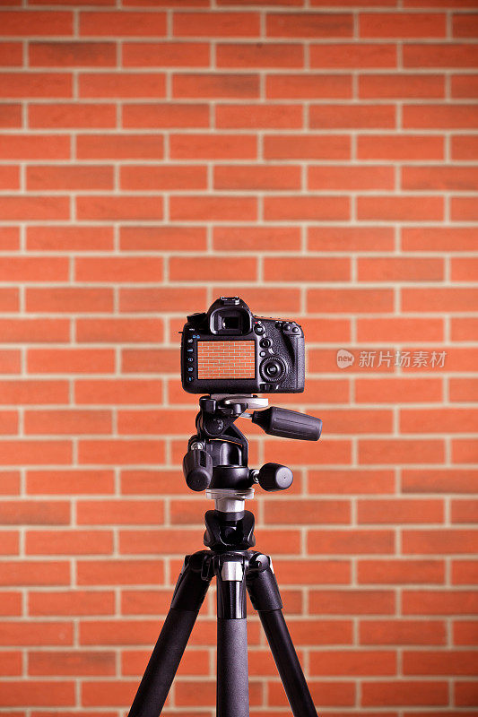 三脚架上的单反相机拍摄砖墙