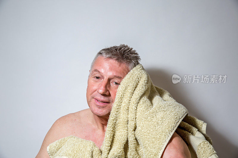 成熟的高级男子在浴室用毛巾擦干