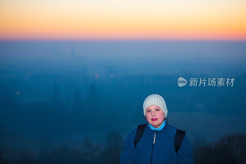 女人摆姿势肖像与美丽的日落背后