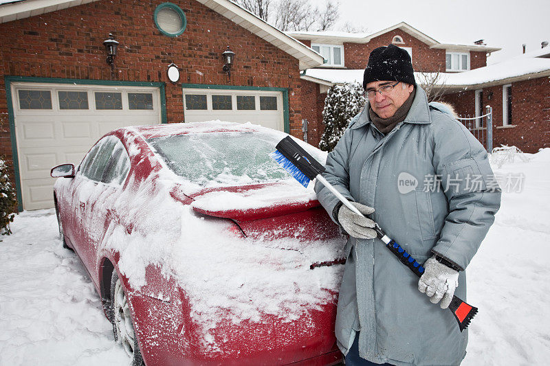 清理车上积雪的人