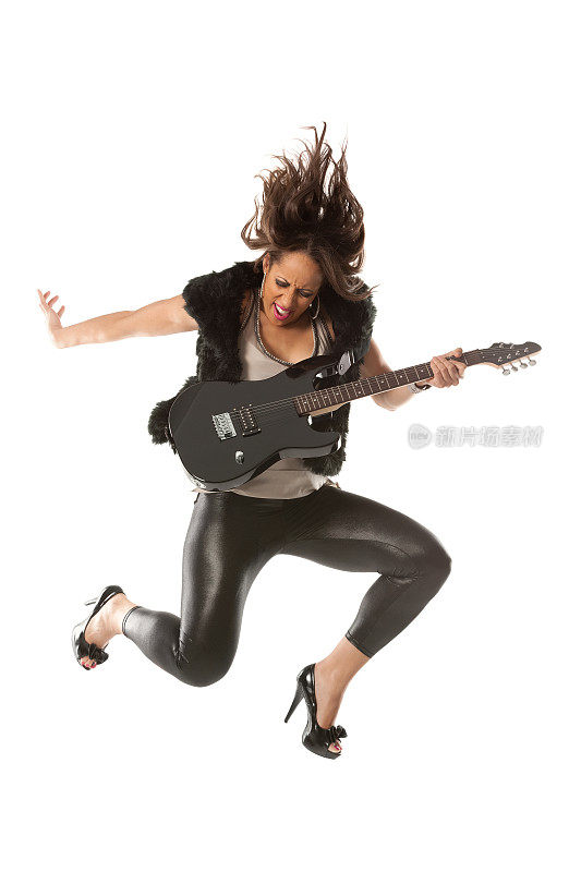 兴奋的女吉他手跳着她的吉他