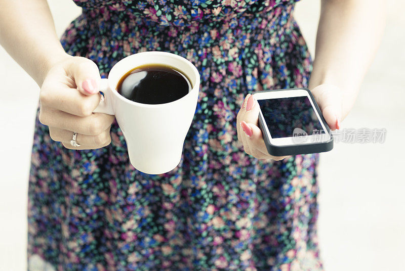 现代生活工作中手捧咖啡和手机