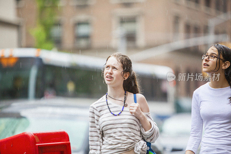 两个十几岁的女孩下雨天在曼哈顿大街上散步