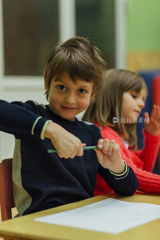 幼儿园里的小男孩在涂色